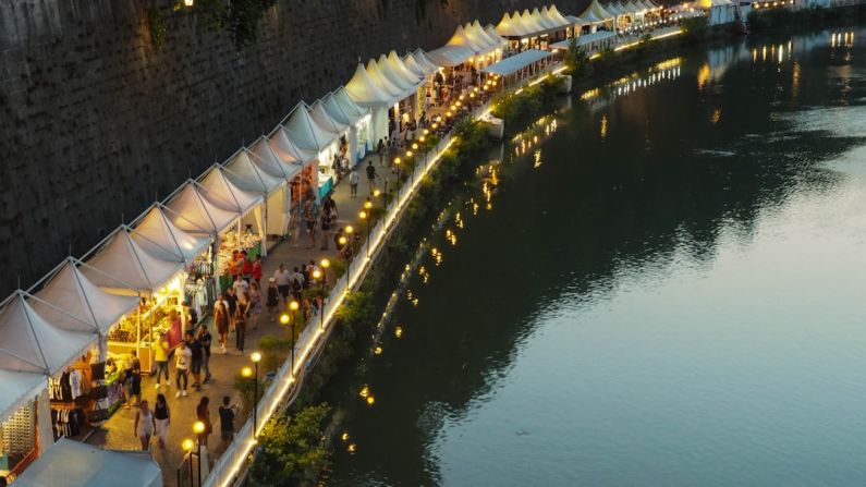 Negotiating Markets - white canopy with stores near body of water during daytime