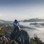 Solo Photography - man on top of mountain taking pictures