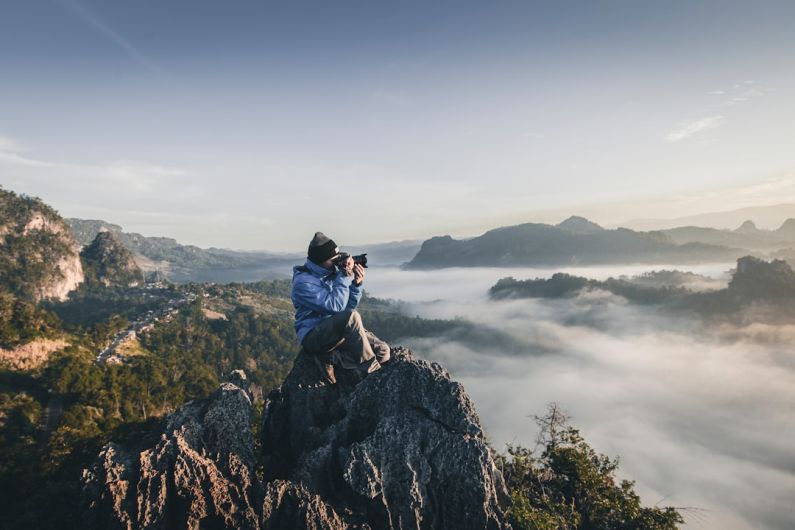 Solo Photography - man on top of mountain taking pictures