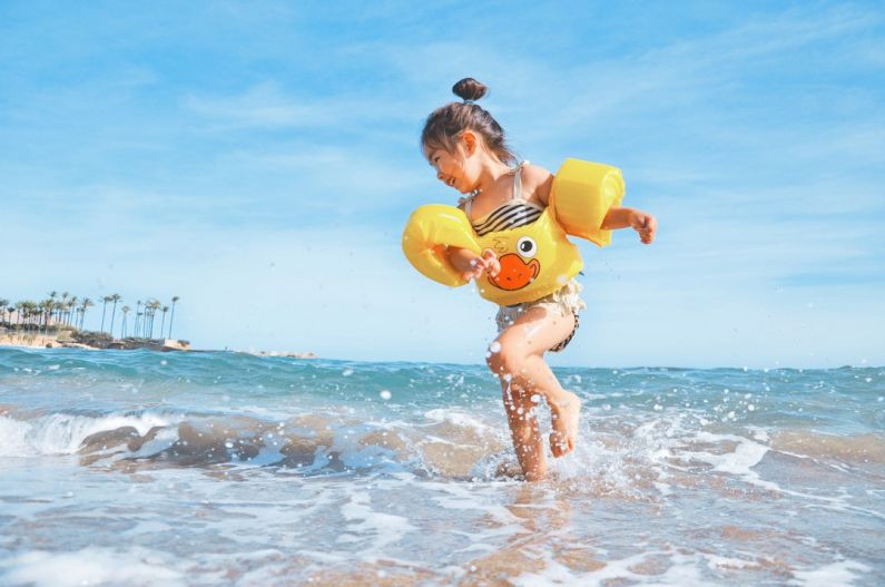 Travel Kids - girl playing beside body of water during daytime