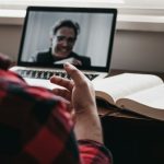 Stay Connected - person in red and black plaid long sleeve shirt using black laptop computer