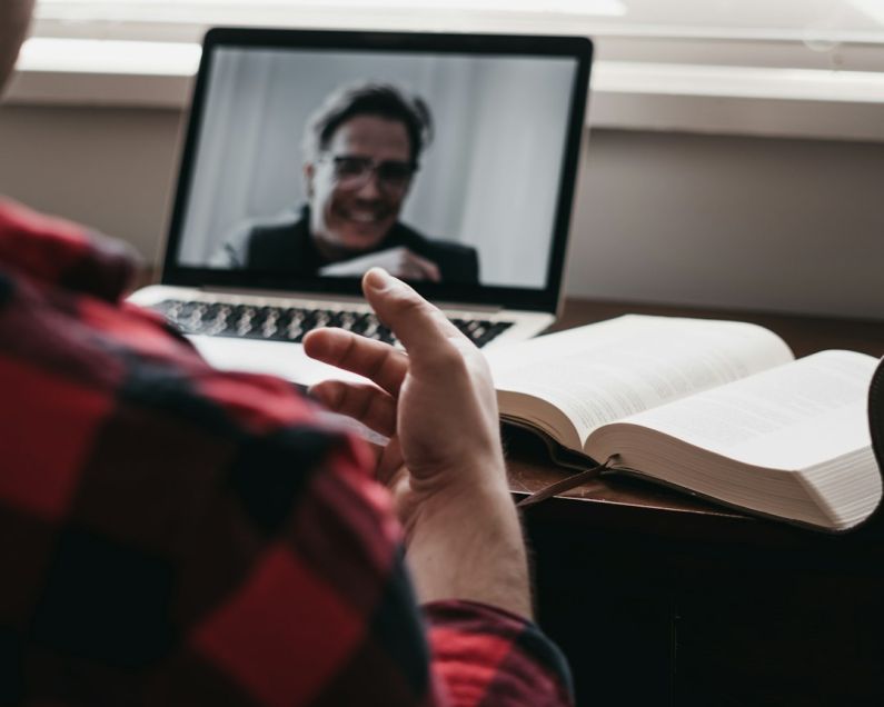 Stay Connected - person in red and black plaid long sleeve shirt using black laptop computer