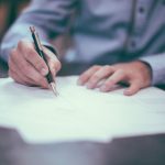 Insurance Importance - man writing on paper