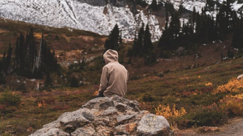 Mountain Retreat - a person sitting on top of a large rock