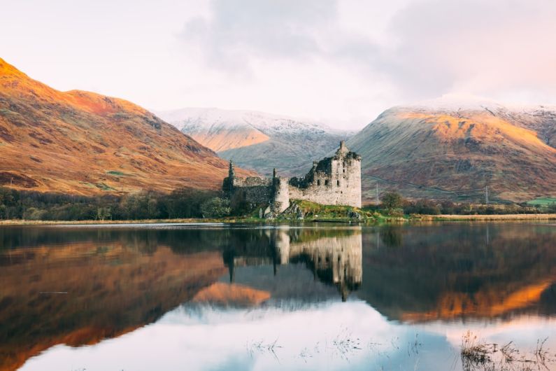 Scottish Highlands - gray concrete building near lake under white sky during daytime