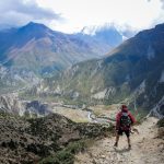 Himalayas Trails - person in red top waling beside mountain