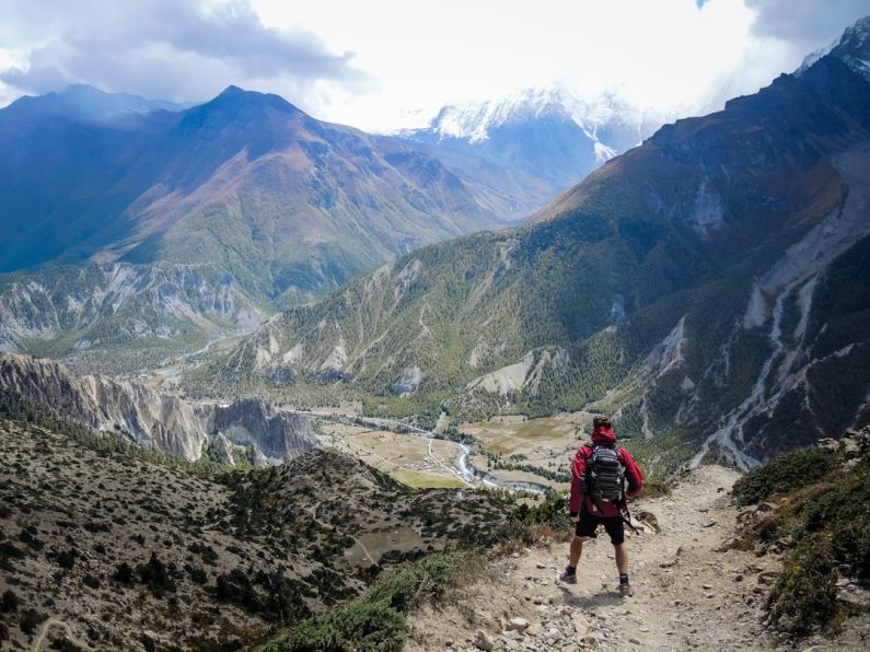 Himalayas Trails - person in red top waling beside mountain