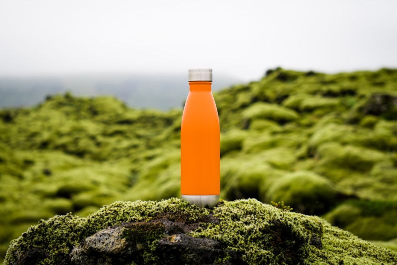 Iceland Budget - orange tumbler on green moss