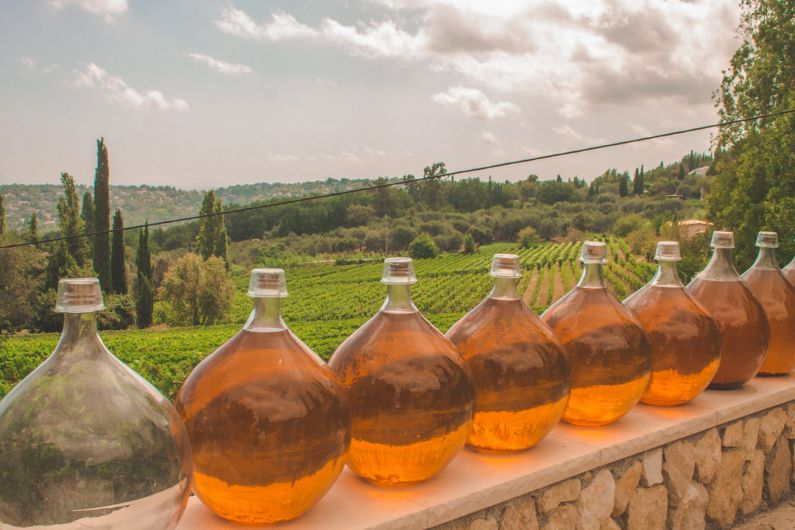 France Vineyards - 3 bottles of brown liquid on brown concrete wall