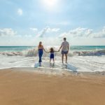Family Vacation - man, woman and child holding hands on seashore