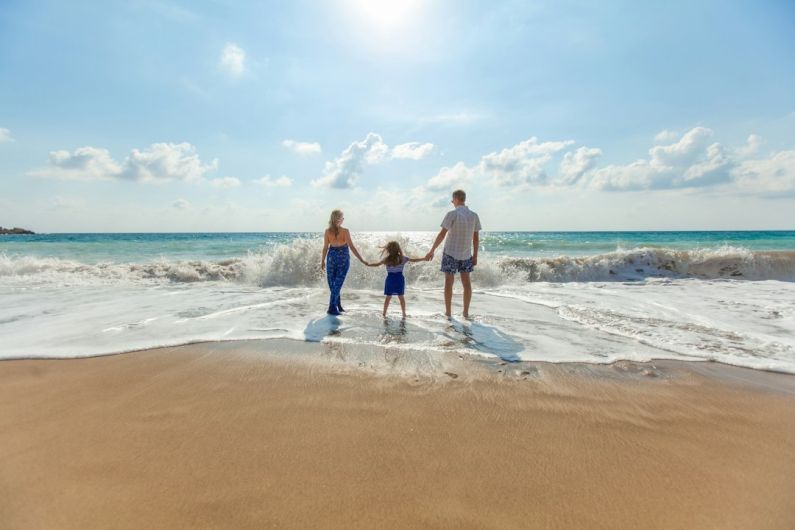 Family Vacation - man, woman and child holding hands on seashore