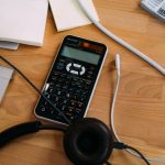 Canada Budget - black scientific calculator beside black headphones
