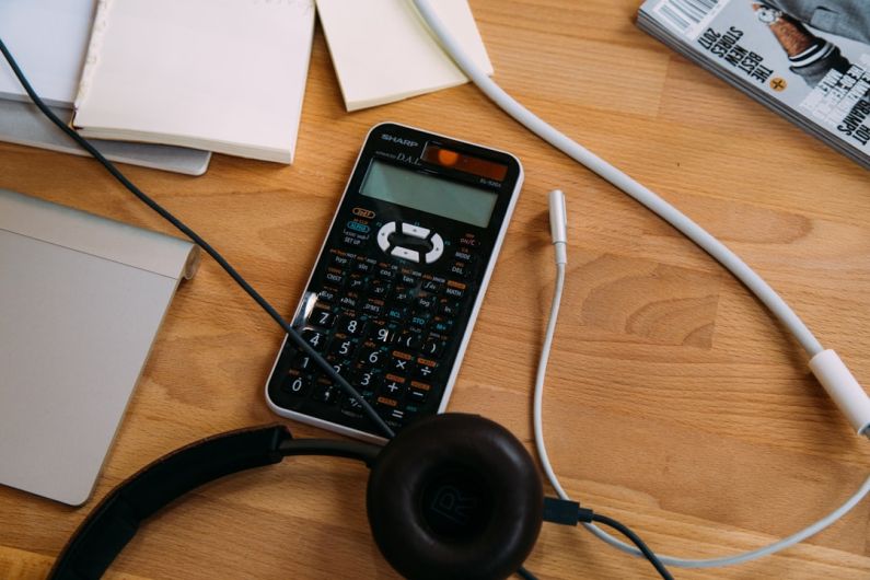 Canada Budget - black scientific calculator beside black headphones