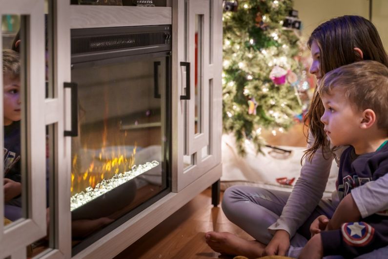Ski Holidays Budget - woman in gray long sleeve shirt sitting on floor beside fireplace