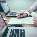 Budget Planning - person holding pencil near laptop computer